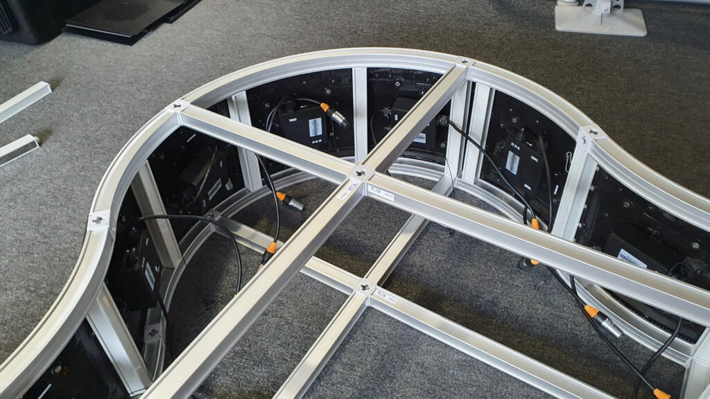 Behind the display panels showing off the structure they are attached to.